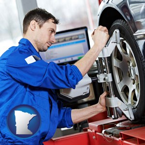 a mechanic adjusting a wheel alignment machine clamp - with Minnesota icon